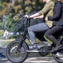 Een stel rijdt op een fatbike, terwijl een hardloper ernaast rent. Nadelen fatbike: minder beweging, meer overlast.