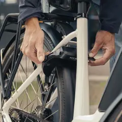 Een persoon bevestigt een ringslot aan een fiets. Dit type slot, wat is een ringslot, beschermt tegen diefstal door het achterwiel te blokkeren.