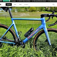 Blauwe racefiets met carbon wielen, klaar om te verkopen. Ideaal om online een racefiets te kopen voor je volgende rit.