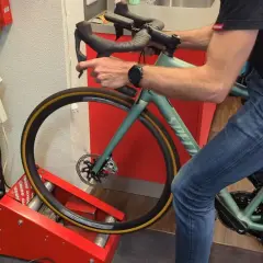Man op een hometrainer, de schijfremmen inremmen door herhaaldelijk te remmen.
