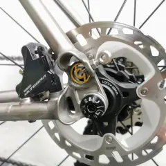 Close-up van schijfremmen op een racefiets. De Shimano Ultegra remklauw en schijfrem zijn duidelijk zichtbaar, klaar voor snelle afdalingen.