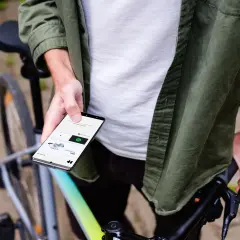 Man op fiets houdt smartphone vast, toont app voor communiceren tijdens fietsen.