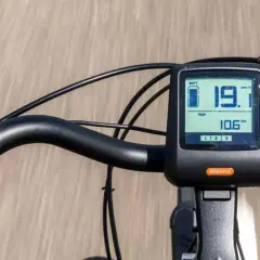 Close-up of an e-bike handlebar with a digital display showing speed and battery level.