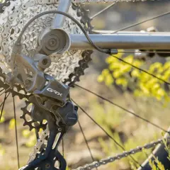 Close-up van een fiets derailleur, met de ketting en tandwielen. De derailleur afstellen is cruciaal voor soepel schakelen.