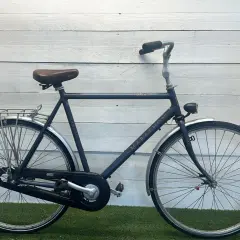 Een donkerblauwe Sparta Marathon, een klassiek model met een retro zadel en bagagedrager. Perfect voor lange ritten.