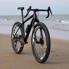 Zwarte racefiets met brede banden op het strand, klaar voor avontuurlijke beach bikes tochten langs de zee.