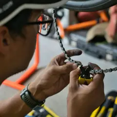 Man met vuile handen is bezig met het kettingblad vervangen van een fiets.