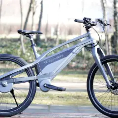 Moderne grijze elektrische fiets zonder ketting, met een strak design en een geïntegreerde accu.