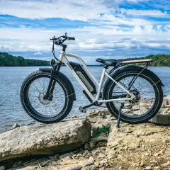 Een elektrische fiets staat op rotsen aan het water. De fiets is klaar voor een avontuur, hopelijk zonder ongelukken.