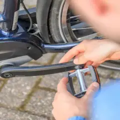 Handen draaien een trapper los van een e-bike met Bosch Active Line motor.