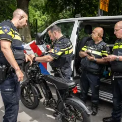 Politieagenten onderzoeken een fatbike. Mogelijk wordt er gekeken naar het opvoeren van de fiets.