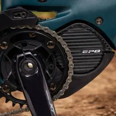 Close-up van een e-bike aandrijfsysteem met Shimano STEPS motor. De ketting loopt over de tandwielen en de motorbehuizing met EP8-logo.