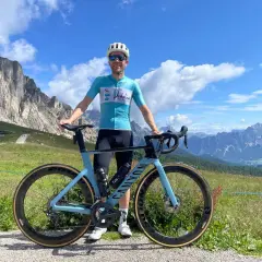 Man met racefiets in de bergen, genietend van gesoigneerd wielrennen.