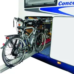 Twee elektrische fietsen staan klaar voor transport in de ruime schuur van een camper.