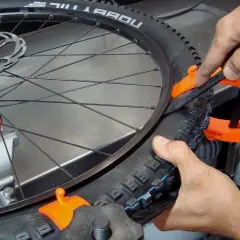 Fietsband monteren lukt niet. Een oranje bandenlichter helpt om de buitenband op de velg te krijgen.