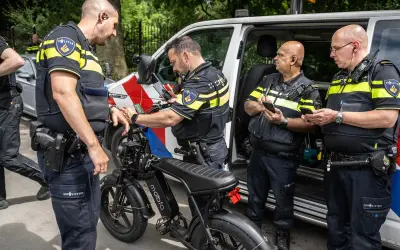 Politieagenten onderzoeken een fatbike. Mogelijk wordt er gekeken naar het opvoeren van de fiets.