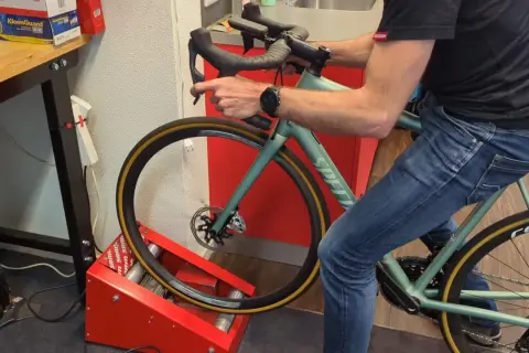 Man op een hometrainer, de schijfremmen inremmen door herhaaldelijk te remmen.