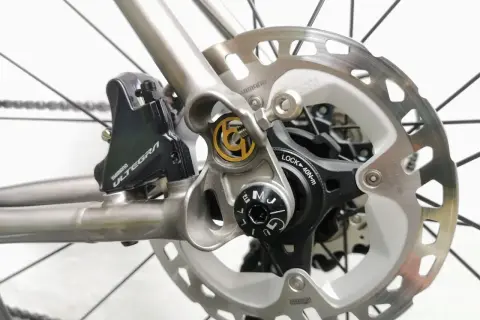 Close-up van schijfremmen op een racefiets. De Shimano Ultegra remklauw en schijfrem zijn duidelijk zichtbaar, klaar voor snelle afdalingen.