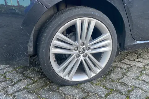 Een lekke band op de racefiets van de auto. De band is plat en de velg rust op de stenen ondergrond.