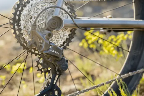 Close-up van een fiets derailleur, met de ketting en tandwielen. De derailleur afstellen is cruciaal voor soepel schakelen.