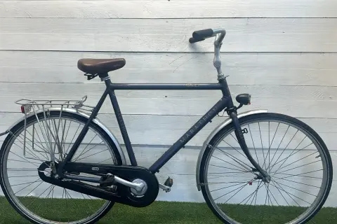 Een donkerblauwe Sparta Marathon, een klassiek model met een retro zadel en bagagedrager. Perfect voor lange ritten.