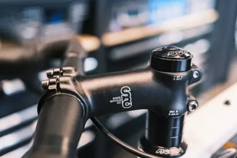 Zwarte fietsstuurpen, merk State Bicycle Co., met spacers om de stuurpen te verhogen voor een comfortabelere fietshouding.
