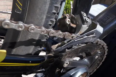 De ketting loopt van voorblad af, de derailleur is zichtbaar.