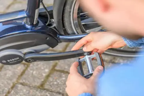 Handen draaien een trapper los van een e-bike met Bosch Active Line motor.