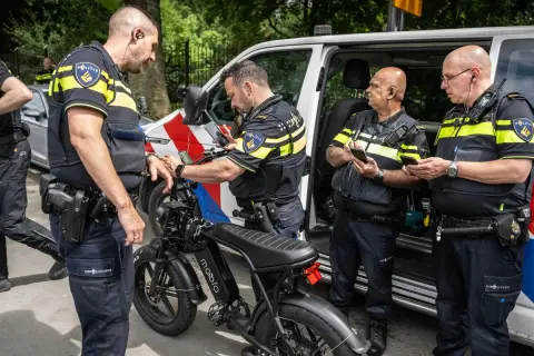 Politieagenten onderzoeken een fatbike. Mogelijk wordt er gekeken naar het opvoeren van de fiets.