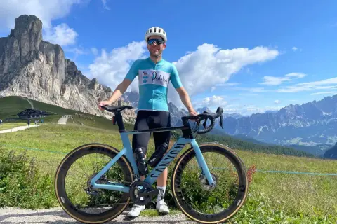 Man met racefiets in de bergen, genietend van gesoigneerd wielrennen.