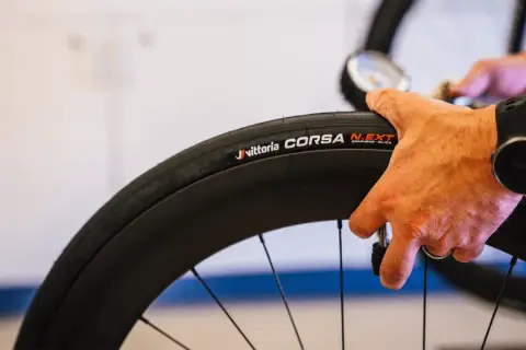 Hand controleert de bandenspanning van een Vittoria Corsa N.EXT tubeless racefiets band.