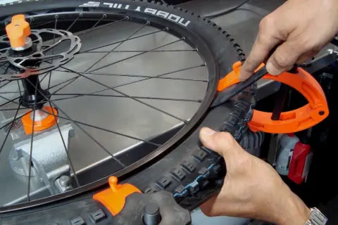 Fietsband monteren lukt niet. Een oranje bandenlichter helpt om de buitenband op de velg te krijgen.