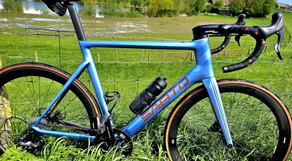 Blauwe racefiets met carbon wielen, klaar om te verkopen. Ideaal om online een racefiets te kopen voor je volgende rit.