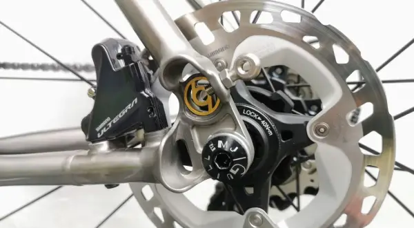 Close-up van schijfremmen op een racefiets. De Shimano Ultegra remklauw en schijfrem zijn duidelijk zichtbaar, klaar voor snelle afdalingen.