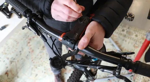 Handen stellen balhoofd fiets af met gereedschap. Zorg dat alles stevig vastzit voor een veilige rit.