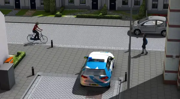Een fietser van rechts nadert een kruispunt. Een ANWB-auto staat stil, een grijze auto rijdt door.