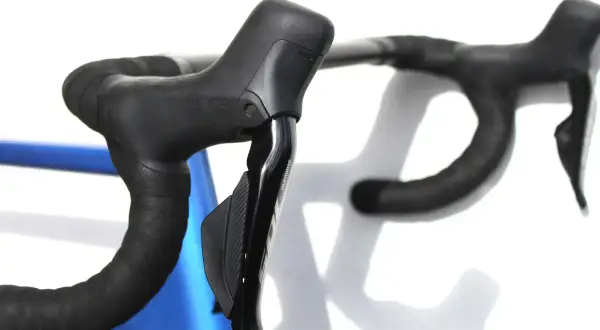 Zwarte racefiets stuur met Shimano Ultegra vs 105 shifters, klaar voor de rit.