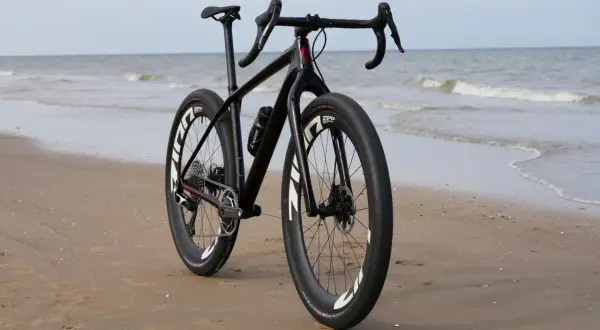 Zwarte racefiets met brede banden op het strand, klaar voor avontuurlijke beach bikes tochten langs de zee.