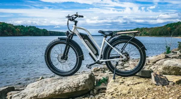 Een elektrische fiets staat op rotsen aan het water. De fiets is klaar voor een avontuur, hopelijk zonder ongelukken.