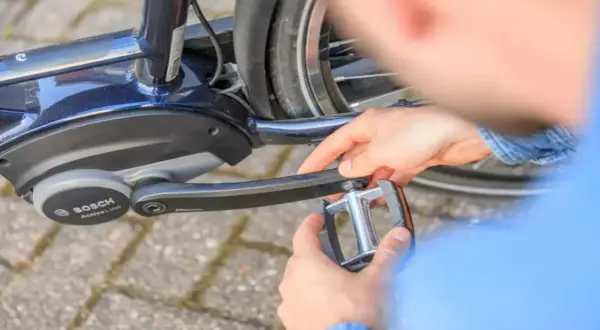 Handen draaien een trapper los van een e-bike met Bosch Active Line motor.