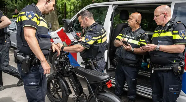 Politieagenten onderzoeken een fatbike. Mogelijk wordt er gekeken naar het opvoeren van de fiets.