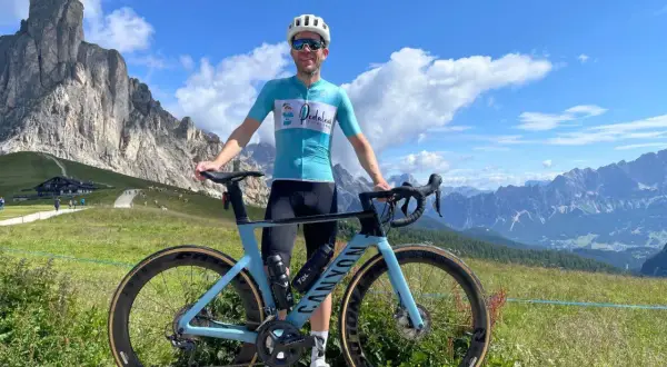 Man met racefiets in de bergen, genietend van gesoigneerd wielrennen.