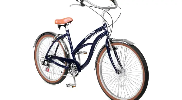 Donkerblauwe beach cruiser fiets met bruin zadel en handvatten, klaar voor een ritje langs de kust.