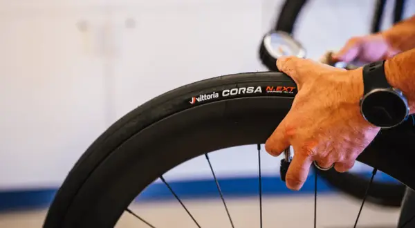 Hand controleert de bandenspanning van een Vittoria Corsa N.EXT tubeless racefiets band.
