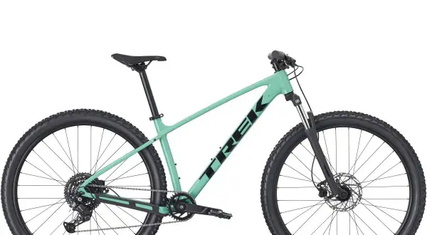 Mintgroene Trek crosshybride fiets met zwarte banden en velgen, klaar voor avontuur.