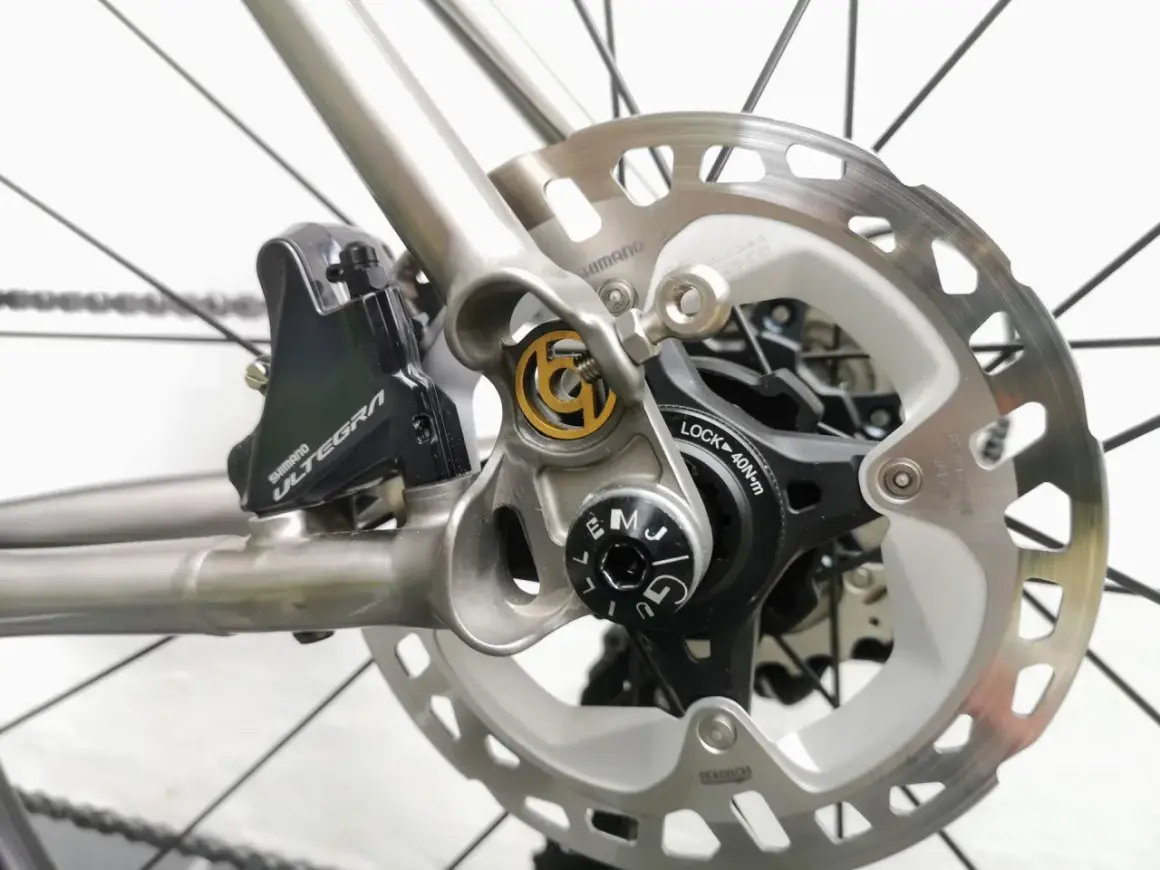 Close-up van schijfremmen op een racefiets. De Shimano Ultegra remklauw en schijfrem zijn duidelijk zichtbaar, klaar voor snelle afdalingen.