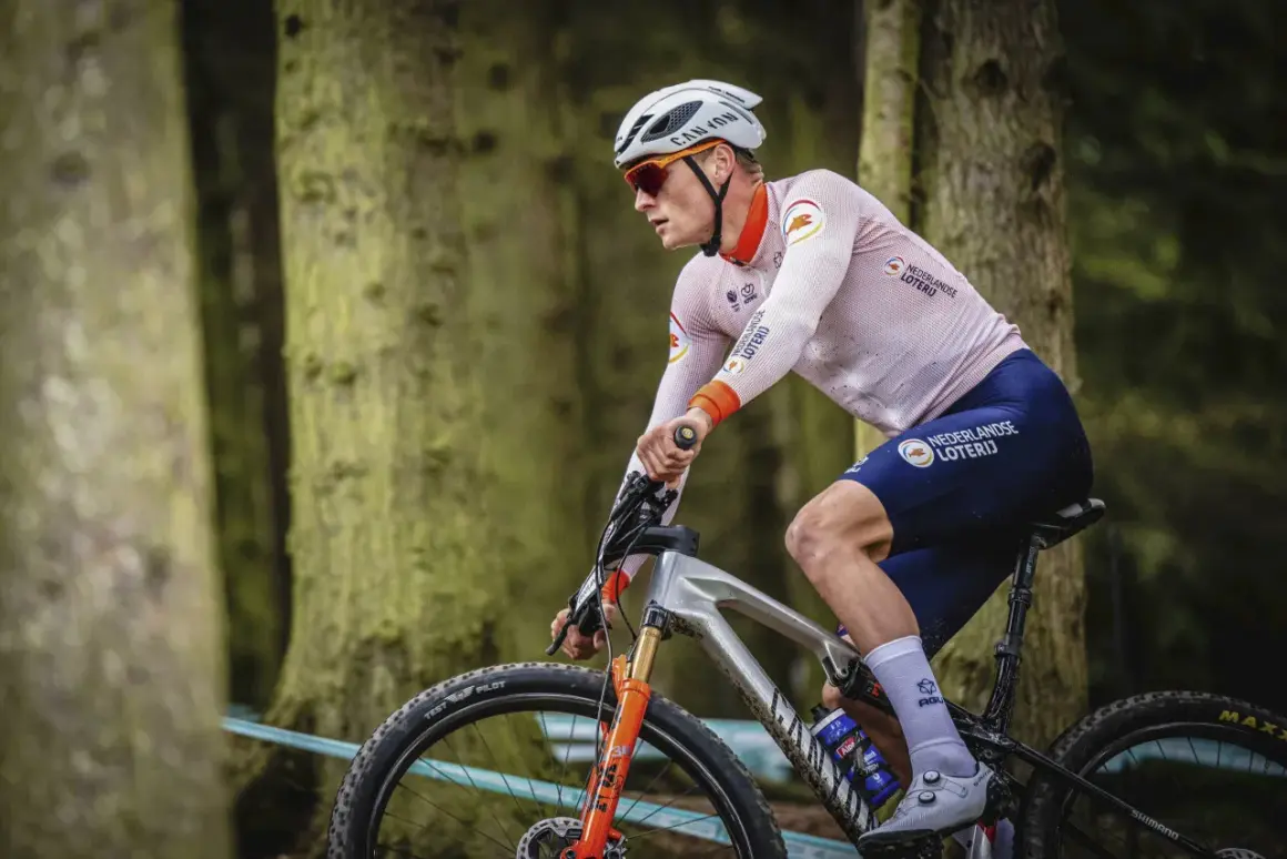 Een Nederlandse wielrenner in actie in het bos, met de Nederlandse Loterij op zijn shirt.