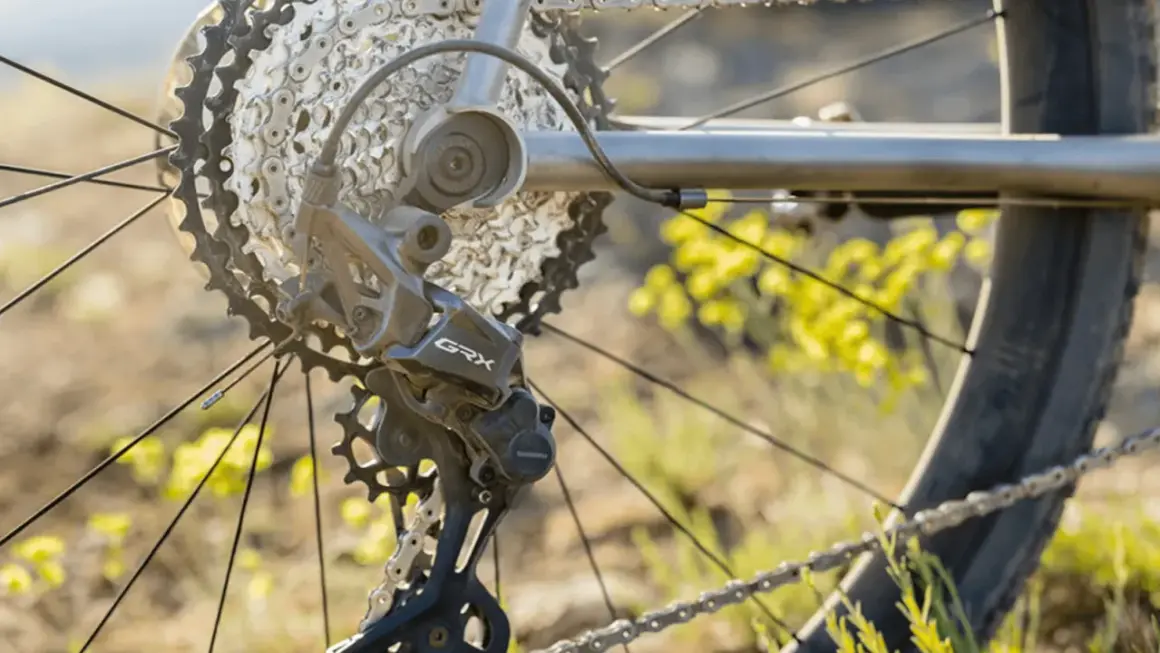 Close-up van een fiets derailleur, met de ketting en tandwielen. De derailleur afstellen is cruciaal voor soepel schakelen.
