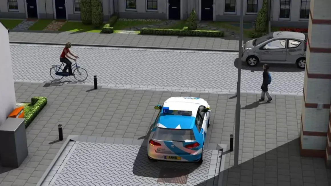 Een fietser van rechts nadert een kruispunt. Een ANWB-auto staat stil, een grijze auto rijdt door.