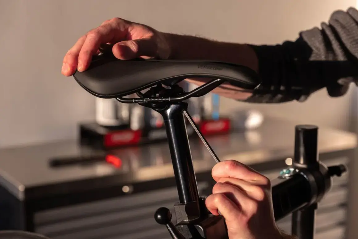Handen die een fietszadel vervangen met een inbussleutel.